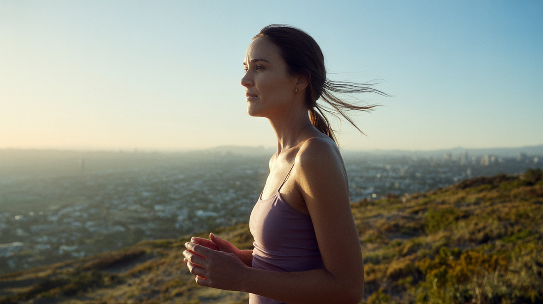 A woman pauses at a hilltop at golden hour — creatine for women guide by PYRRA